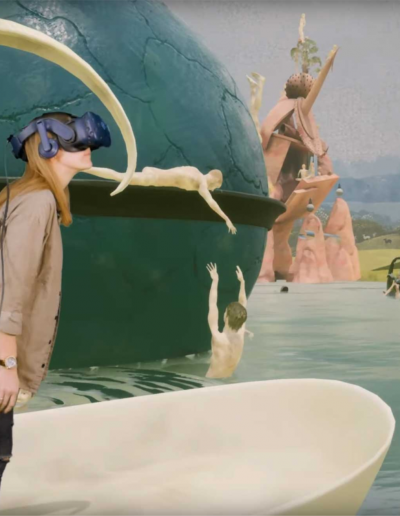 Virtulle Ansicht des Garten der Lüste von Hieronymus Bosch. Eine Frau steht auf einem virtuellen Boot und hat ein VR Headset auf und blickt nach rechts.